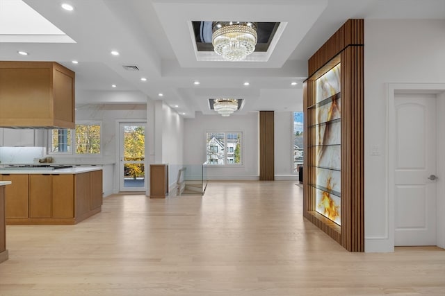 interior space featuring light hardwood / wood-style flooring, a notable chandelier, and premium range hood