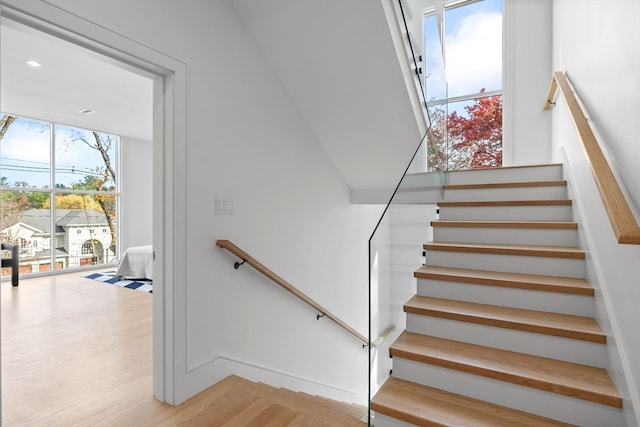 stairs featuring wood-type flooring and a healthy amount of sunlight