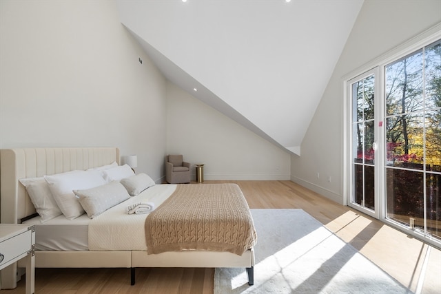 bedroom with light wood-type flooring and lofted ceiling