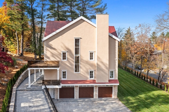 back of house with a garage and a yard