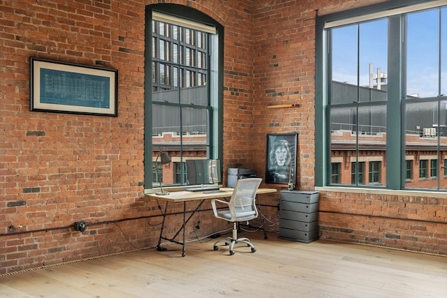 office space featuring brick wall and wood-type flooring