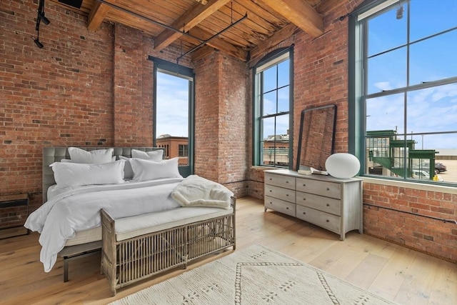 bedroom with brick wall, wood ceiling, light hardwood / wood-style floors, and beamed ceiling