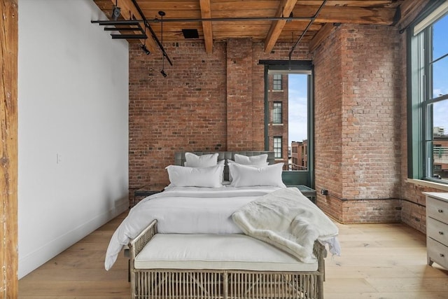 unfurnished bedroom with brick wall, light wood-type flooring, wood ceiling, and beam ceiling