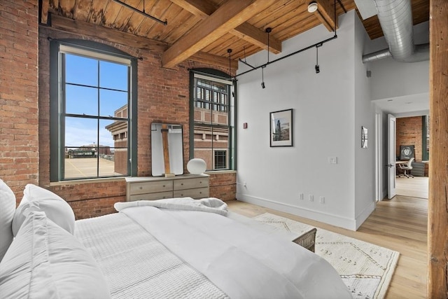 bedroom featuring beam ceiling, wood ceiling, and brick wall