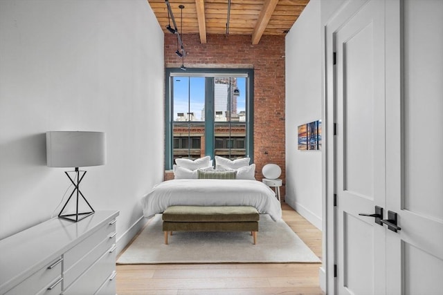 bedroom with wood ceiling, brick wall, light hardwood / wood-style floors, and beamed ceiling