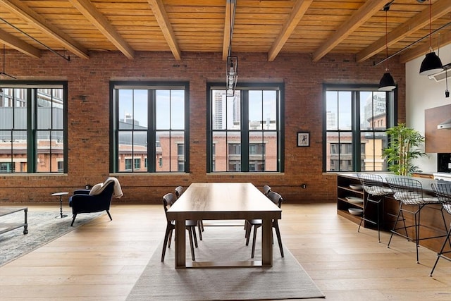 dining room featuring light wood-type flooring, beam ceiling, and wood ceiling