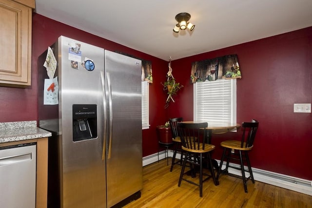 kitchen featuring stainless steel appliances, light brown cabinetry, and light hardwood / wood-style flooring