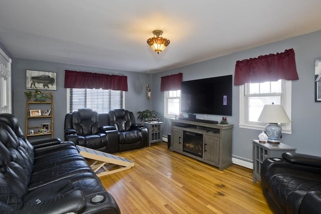 living room with a baseboard radiator and light hardwood / wood-style flooring