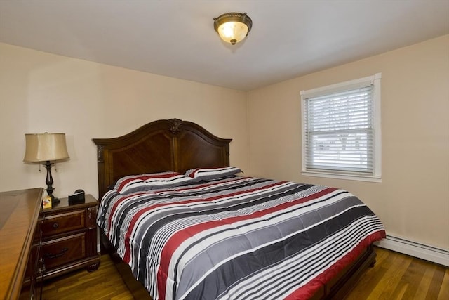 bedroom with a baseboard heating unit and dark wood-type flooring