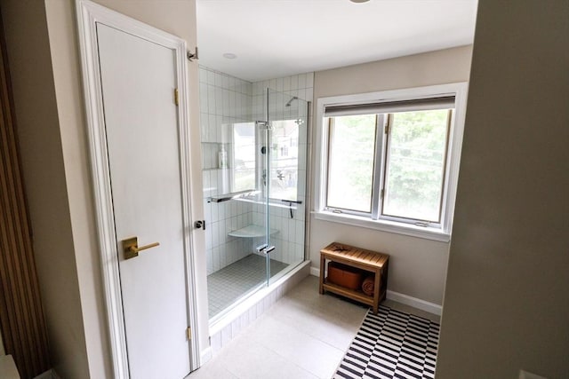 bathroom with baseboards and a stall shower