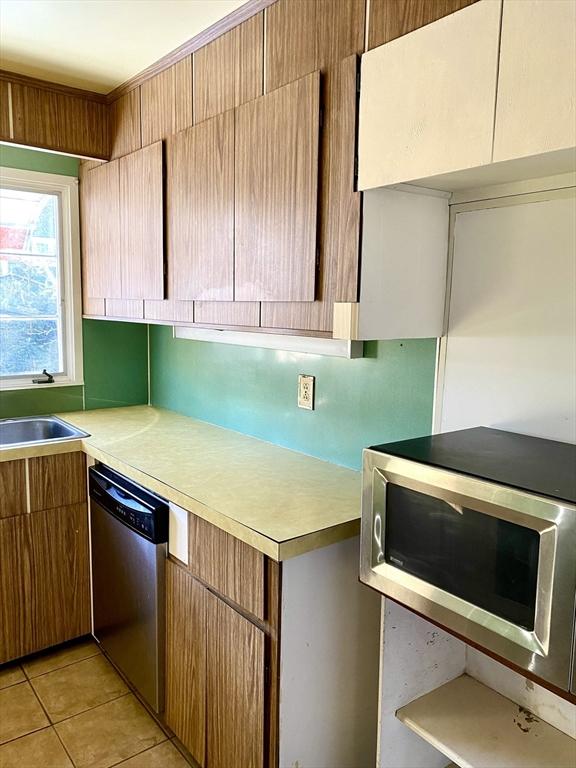 kitchen featuring stainless steel appliances, sink, and light tile patterned floors