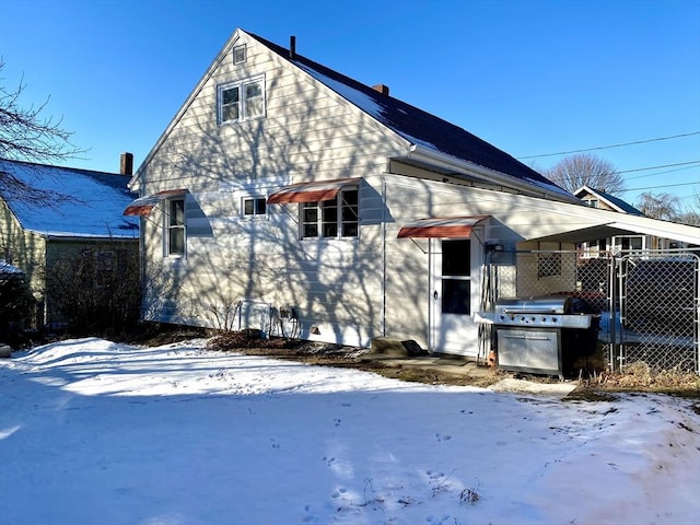 view of snow covered rear of property