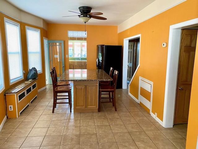 tiled dining room featuring sink and ceiling fan