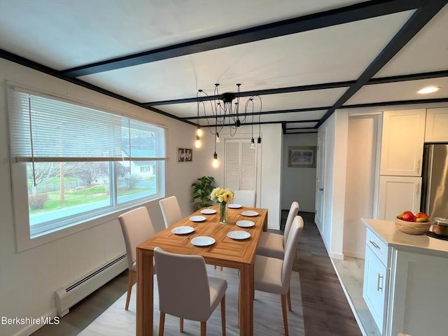 dining room with beamed ceiling, light wood finished floors, baseboards, a baseboard radiator, and an inviting chandelier