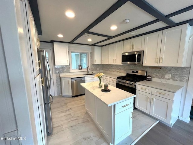kitchen featuring tasteful backsplash, marble finish floor, a sink, white cabinets, and appliances with stainless steel finishes
