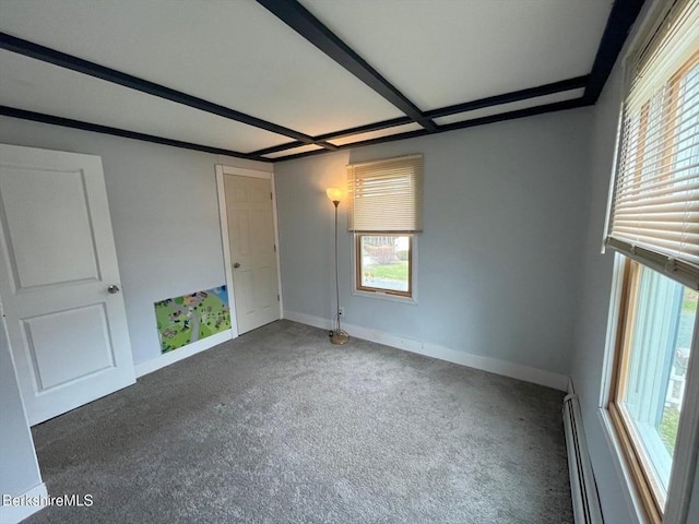 carpeted spare room with a baseboard radiator and baseboards