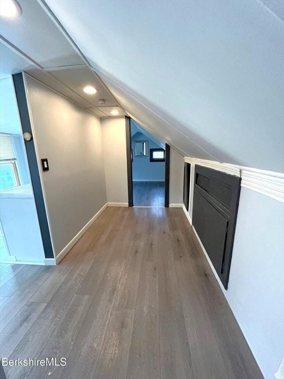 bonus room featuring baseboards, lofted ceiling, and wood finished floors