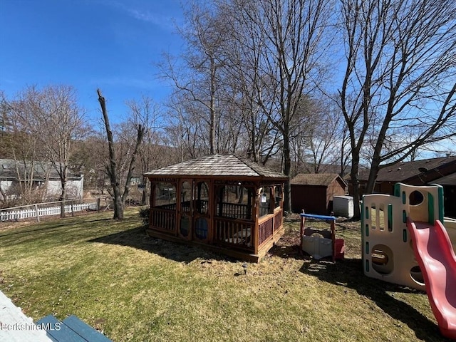 view of yard with an outdoor structure, a playground, a gazebo, and fence