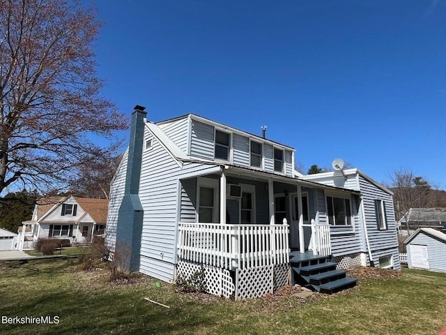 view of front of property with a front lawn, a chimney, and covered porch
