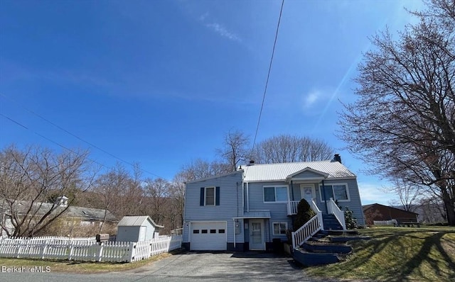 view of front of home with metal roof, fence, an attached garage, a chimney, and driveway