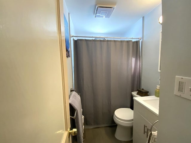 bathroom featuring vanity, walk in shower, and toilet