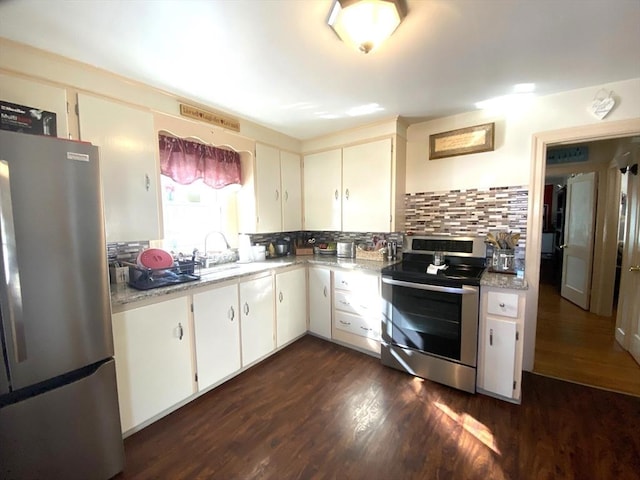 kitchen featuring appliances with stainless steel finishes, dark hardwood / wood-style floors, sink, white cabinets, and decorative backsplash