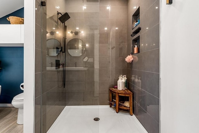bathroom with toilet and a tile shower