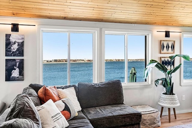 interior space featuring wood ceiling, baseboards, a water view, and wood finished floors