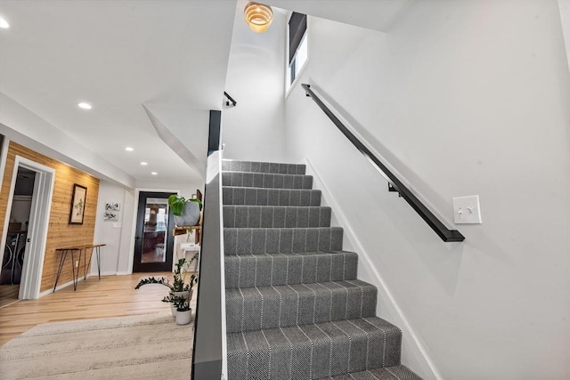 stairway featuring recessed lighting, baseboards, wood walls, and wood finished floors