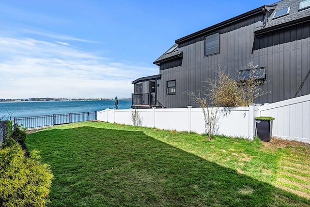 view of yard with a water view and fence
