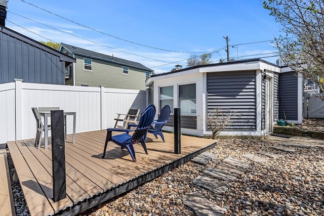 wooden terrace featuring an outdoor structure and fence