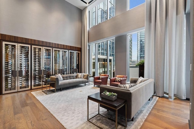 living room with a towering ceiling and light hardwood / wood-style flooring