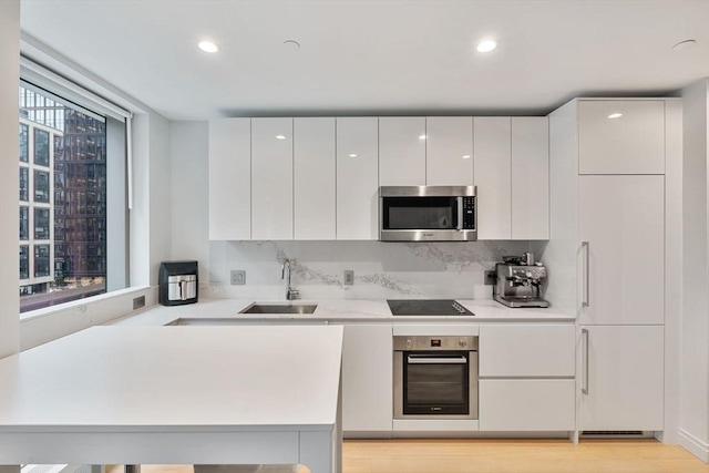 kitchen featuring white cabinetry, sink, stainless steel appliances, and plenty of natural light