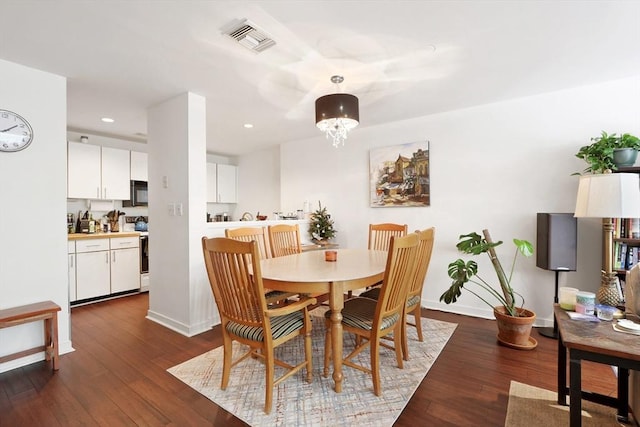 dining room featuring dark hardwood / wood-style flooring and a chandelier