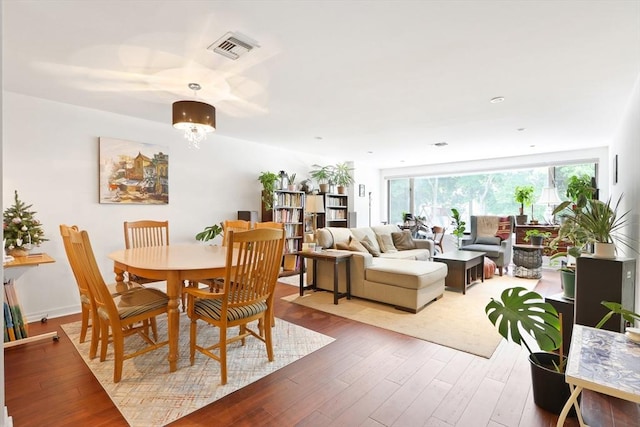 dining room with hardwood / wood-style floors and a notable chandelier