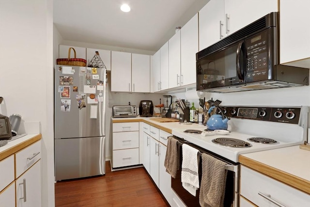 kitchen featuring dark hardwood / wood-style floors, white range with electric cooktop, stainless steel fridge, and white cabinets