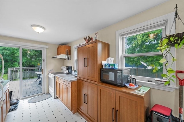 251 Main St, Ashland, MA 01721 - kitchen with white electric range, ventilation hood, black microwave, brown cabinets, and light flooring