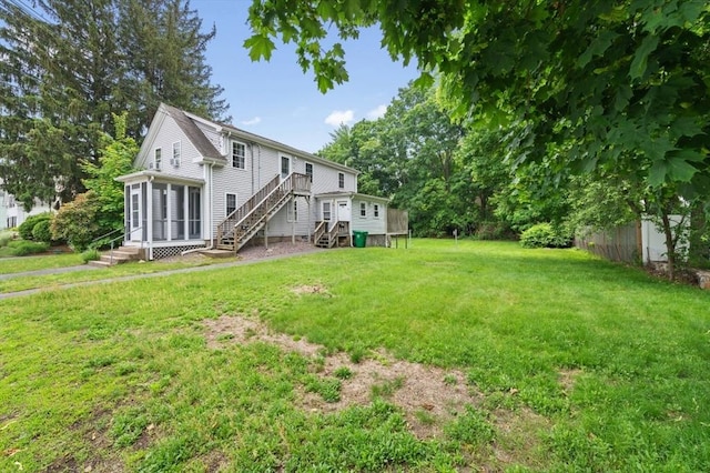 251 Main St, Ashland, MA 01721 - view of green lawn featuring stairway, a sunroom, and a deck