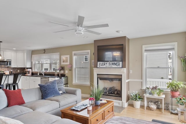 13 11th St W, Salisbury, MA 01952 - living area with a ceiling fan, light wood-type flooring, baseboards, recessed lighting, and a glass covered fireplace