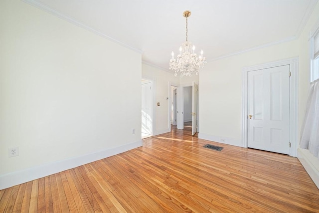 empty room with light hardwood / wood-style flooring, crown molding, and an inviting chandelier