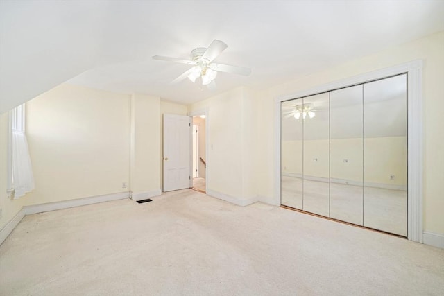 unfurnished bedroom with ceiling fan, light carpet, and a closet