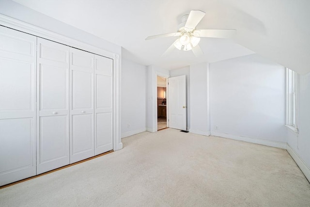 unfurnished bedroom with ceiling fan, light carpet, and a closet