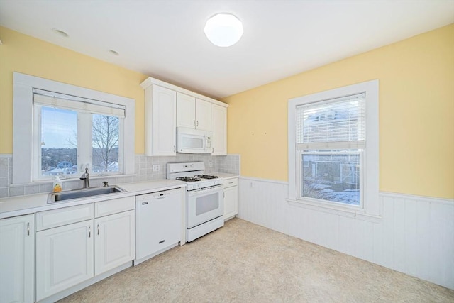 kitchen featuring white cabinets, decorative backsplash, white appliances, and sink