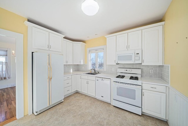 kitchen featuring backsplash, white cabinetry, sink, and white appliances