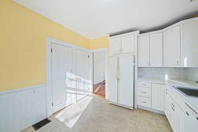 kitchen featuring white cabinets, backsplash, white appliances, and sink