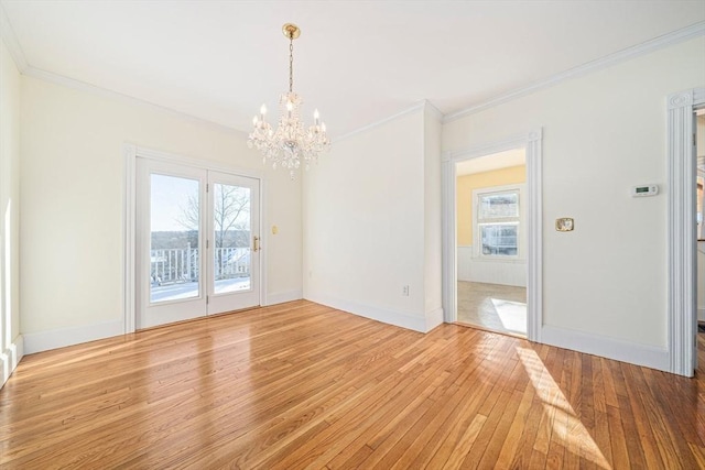 unfurnished dining area featuring light hardwood / wood-style floors, an inviting chandelier, plenty of natural light, and ornamental molding