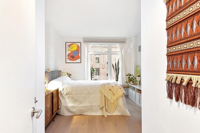 bedroom featuring wood finished floors and access to exterior