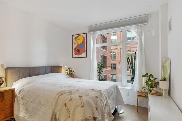 bedroom featuring visible vents and wood finished floors