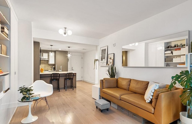 living area featuring light wood-style flooring and baseboards