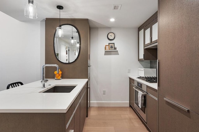 kitchen with visible vents, light wood-type flooring, light countertops, stainless steel appliances, and a sink